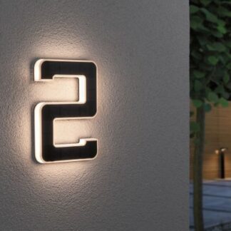 Kinkiet zewnętrzny LED w kształcie cyfry 2 zamontowany na szarej ścianie z podświetleniem.