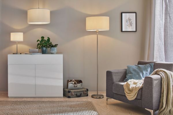Lampa podłogowa Tessa przy fotelu w salonie