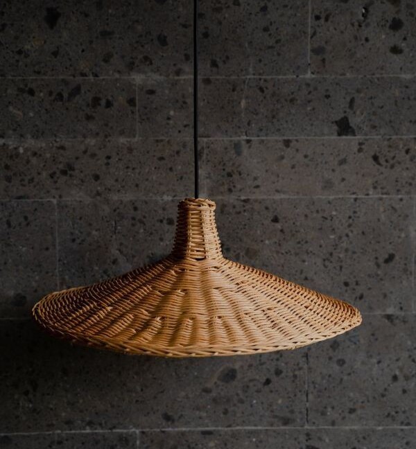 Naturalna, wiklinowa lampa wisząca Sutter w kształcie charakterystycznego kapelusza boho, zawieszona na minimalistycznym czarnym przewodzie. Idealna do wnętrz w stylu skandynawskim, japandi i rustykalnym.