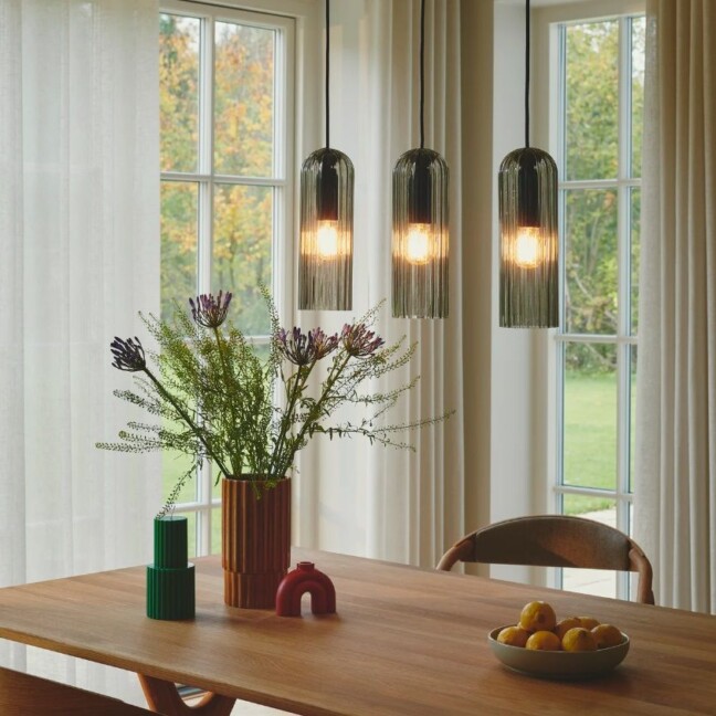 Potrojna lampa wiszaca nad stol w salonie Miella