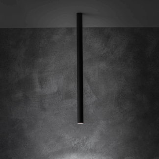 Architektoniczna czarna lampa sufitowa Fourty M w formie smukłej, pionowej tuby (75 cm), tworząca dramatyczny, wąski snop światła na betonowej ścianie, doskonała do akcentowego oświetlenia przestrzeni loftowych.