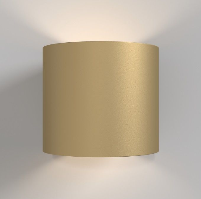 Mały cylindryczny kinkiet w złotym kolorze Rond, oświetlający przestrzeń w górę i w dół.