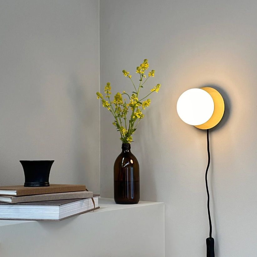 Mosiężny kinkiet SIA z białym szklanym kloszem w kształcie kuli