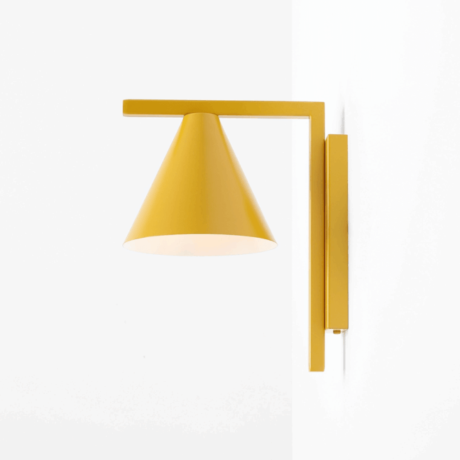 Kolorowy żółty kinkiet Forma retro ze stożkowym kloszem na geometrycznym ramieniu. Minimalistyczna lampa ścienna w intensywnym musztardowym odcieniu na białym tle. Stylowe oświetlenie do wnętrz skandynawskich i mid-century.