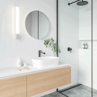 Biały kinkiet LED Sjaver IP44 do łazienki z funkcją ściemniania przy okrągłym lustrze. Nowoczesna, minimalistyczna aranżacja z drewnianą szafką i umywalką nablatową. Bezpieczne oświetlenie do wilgotnych pomieszczeń.