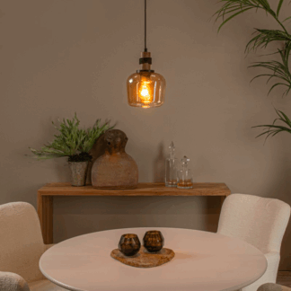 Bursztynowa szklana lampa wisząca Ilona z drewnianymi i metalowymi elementami, zawieszona nad białym okrągłym stołem w przytulnej jadalni z beżowymi krzesłami, drewnianą półką i dekoracjami w naturalnych odcieniach.