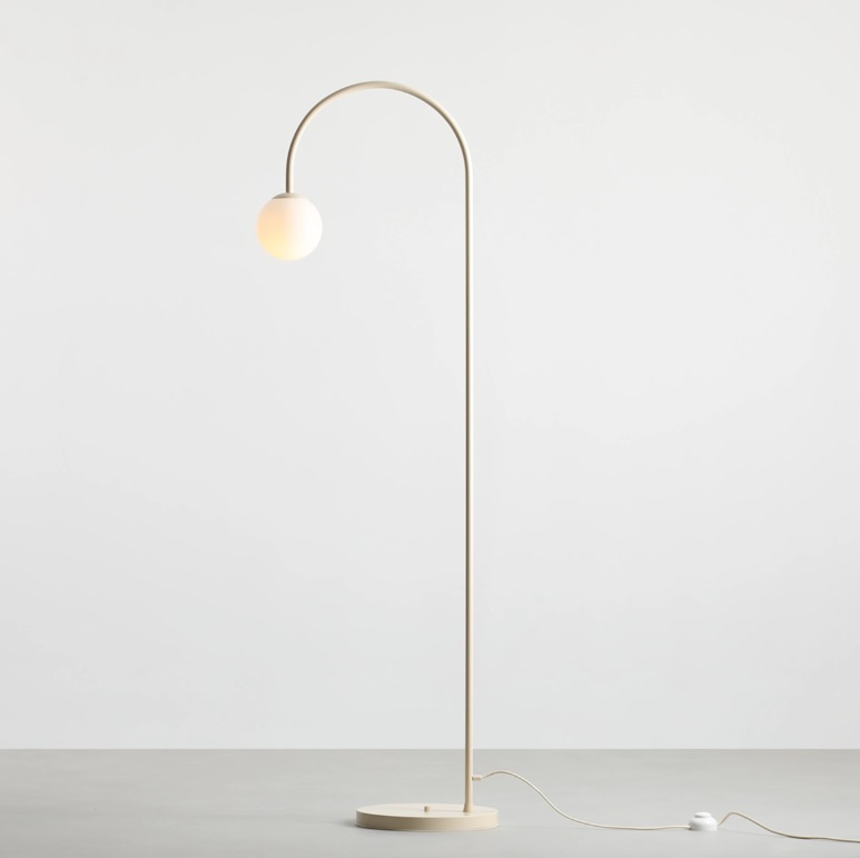 Stylowa lampa podłogowa Una w kremowym kolorze z kulistym kloszem na wygiętym ramieniu