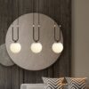 Nowoczesna lampa wisząca Glam 3 z trzema mlecznymi kloszami na dekoracyjnym łuku