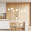 Złota lampa wisząca Gravity 8 z mlecznymi kulami E14